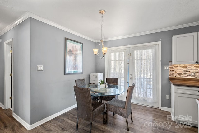 dining room featuring a notable chandelier, dark hardwood / wood-style flooring, crown molding, and french doors