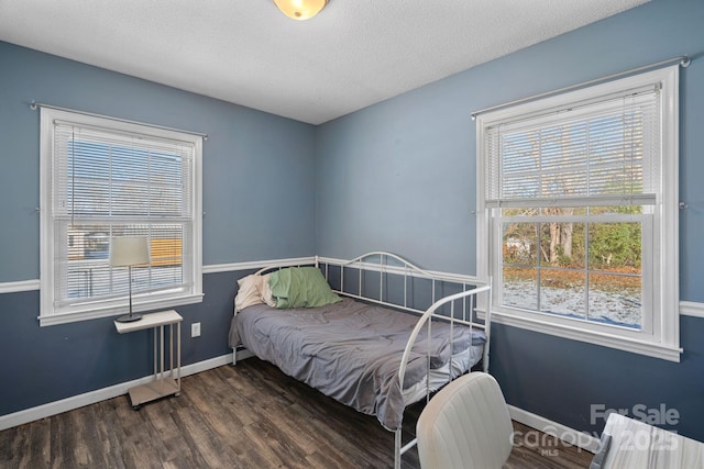 bedroom with dark wood-type flooring and a textured ceiling