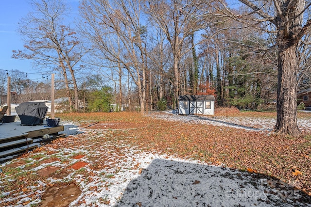 yard covered in snow with a storage shed