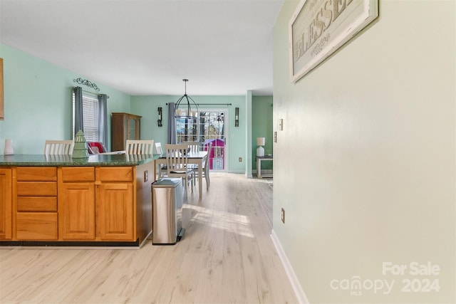 kitchen featuring light wood-type flooring, an inviting chandelier, and hanging light fixtures