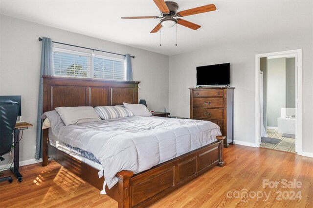 bedroom featuring ensuite bath, light hardwood / wood-style flooring, and ceiling fan