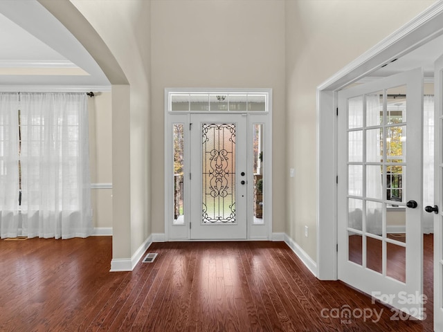 foyer entrance featuring crown molding and dark hardwood / wood-style floors