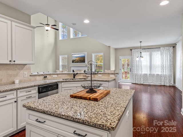 kitchen featuring sink, white cabinets, stainless steel dishwasher, and a kitchen island