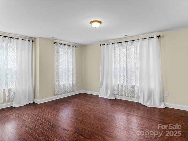 empty room featuring dark hardwood / wood-style flooring and a healthy amount of sunlight