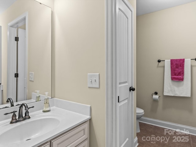 bathroom with toilet, tile patterned floors, and vanity