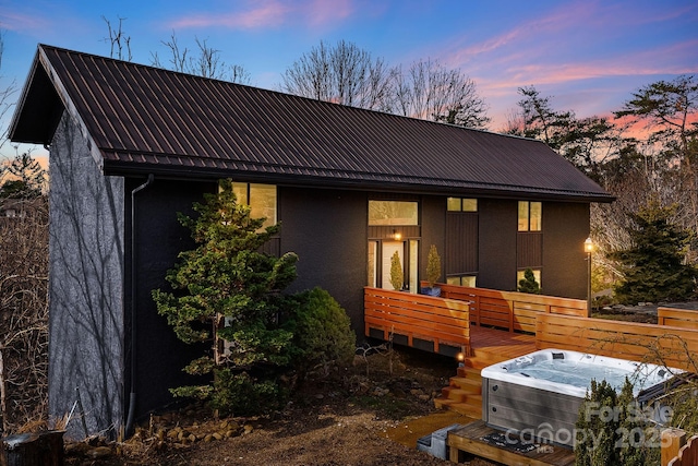 back house at dusk featuring central AC unit and a wooden deck