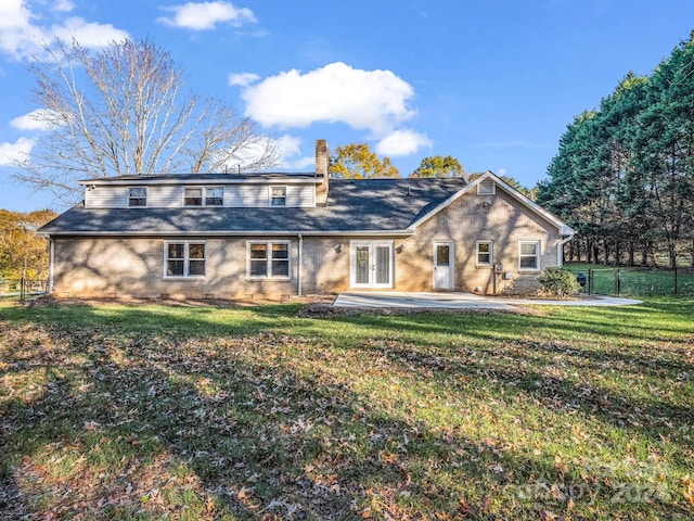 view of front of house with french doors, a front lawn, and a patio area