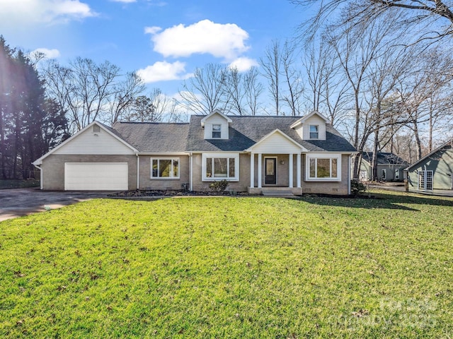 new england style home with aphalt driveway, a garage, brick siding, roof with shingles, and a front yard