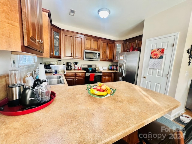 kitchen with kitchen peninsula, a kitchen breakfast bar, and stainless steel appliances