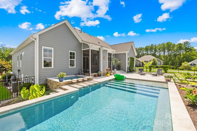 back of house with a pool with hot tub, a patio area, and a sunroom