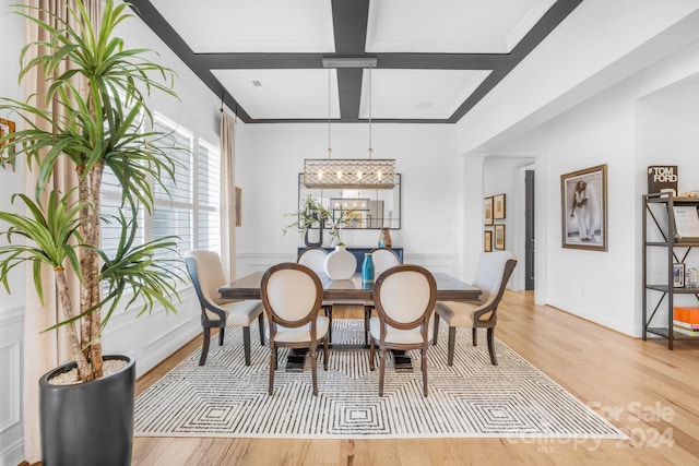 dining space with beam ceiling, light hardwood / wood-style floors, crown molding, and coffered ceiling