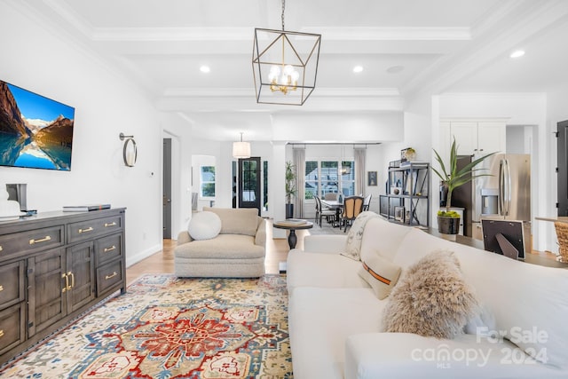 living room featuring crown molding, an inviting chandelier, beamed ceiling, and light wood-type flooring