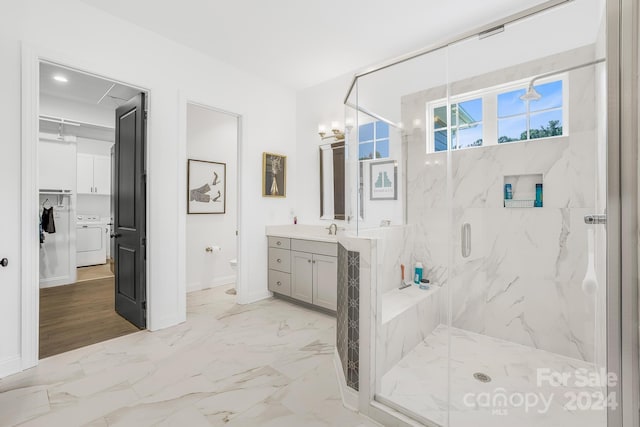 bathroom with vanity, toilet, a notable chandelier, an enclosed shower, and washer / dryer