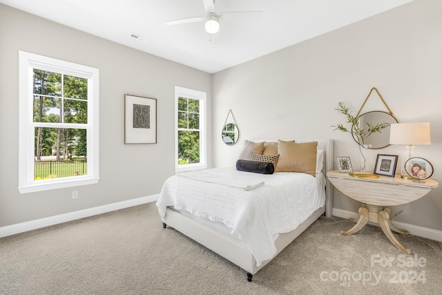 bedroom with carpet flooring, ceiling fan, and multiple windows