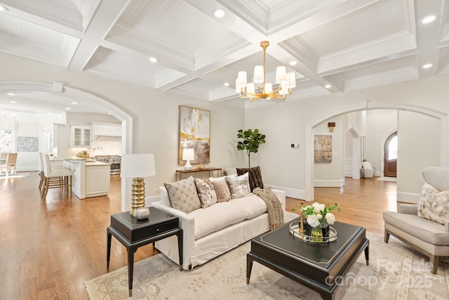 living area with arched walkways, light wood-type flooring, coffered ceiling, and beam ceiling