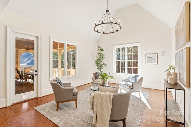 interior space featuring high vaulted ceiling, light wood-type flooring, an inviting chandelier, and a healthy amount of sunlight