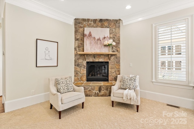 sitting room with a stone fireplace, a wealth of natural light, visible vents, and crown molding