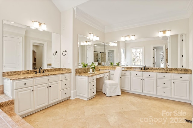 full bath featuring two vanities, crown molding, visible vents, and a sink