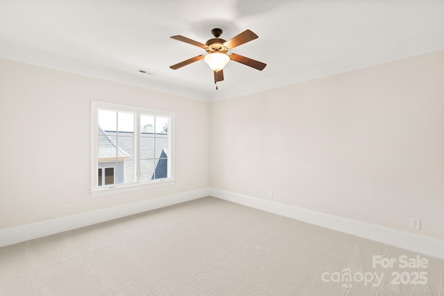 empty room featuring visible vents, crown molding, and light colored carpet