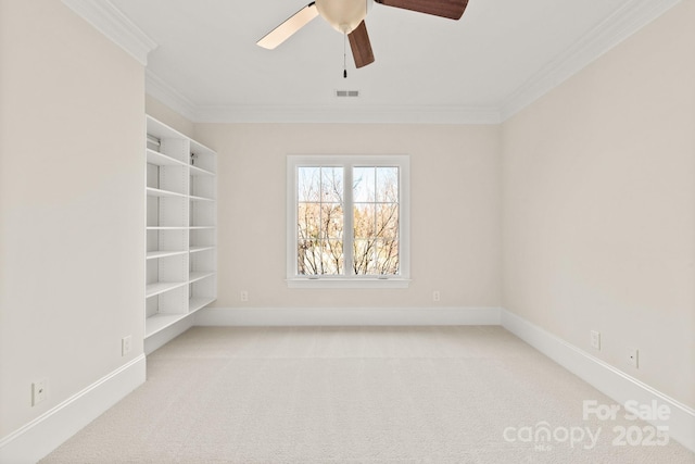 spare room featuring carpet floors, ornamental molding, and baseboards