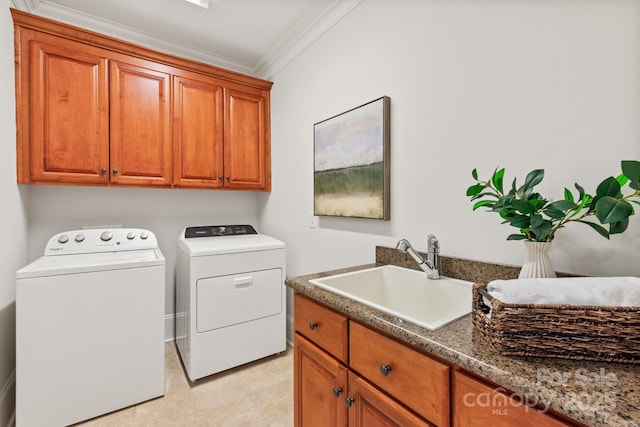 laundry area with crown molding, cabinet space, a sink, and washing machine and clothes dryer