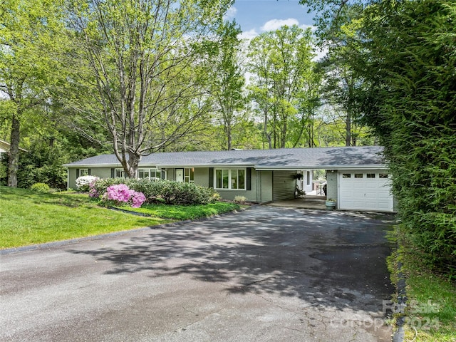 ranch-style home featuring a carport and a front lawn