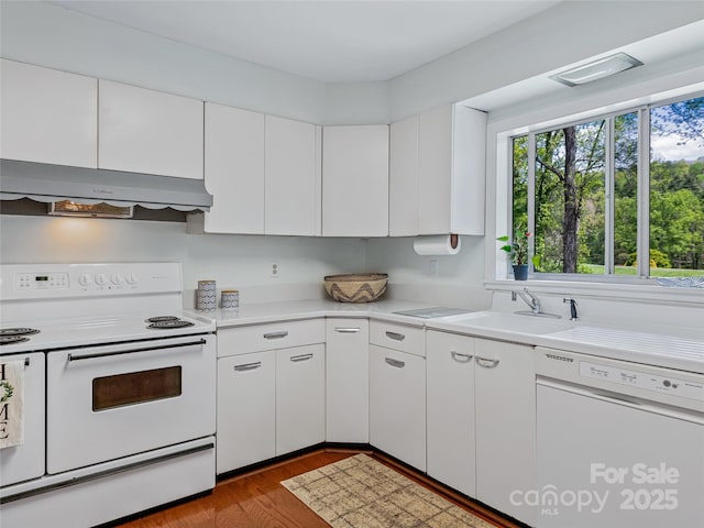 kitchen featuring exhaust hood, hardwood / wood-style flooring, white cabinets, and white appliances