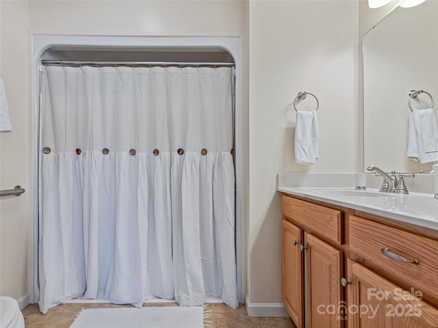 bathroom with tile patterned flooring, walk in shower, and vanity