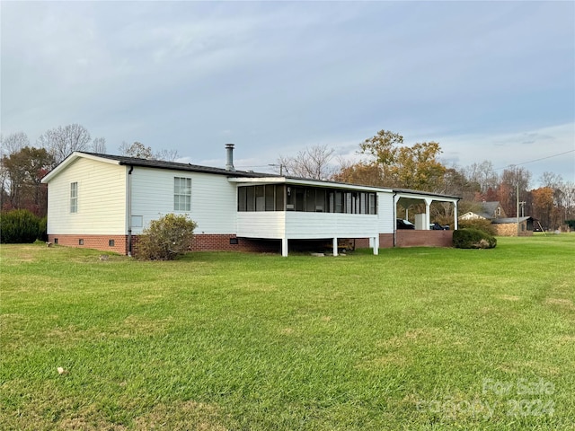 back of house featuring a sunroom and a yard