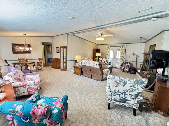 living room featuring ceiling fan with notable chandelier, french doors, carpet, and a textured ceiling