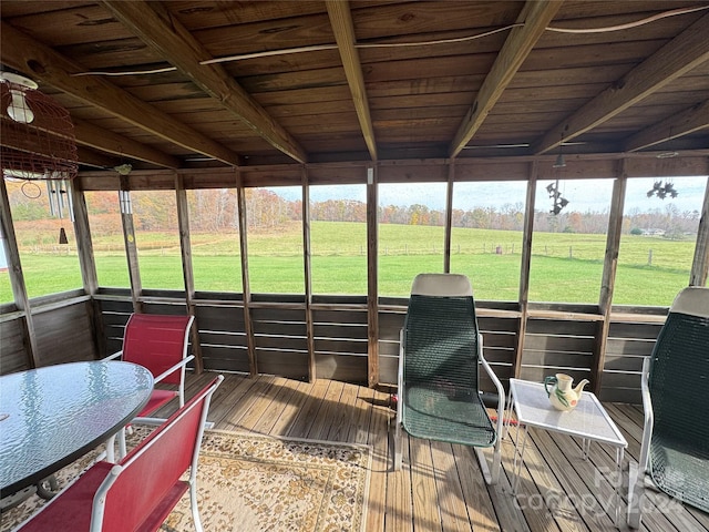 sunroom featuring wood ceiling, a rural view, and beam ceiling