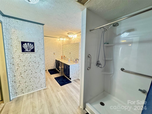 bathroom featuring a shower, hardwood / wood-style floors, a textured ceiling, and vanity