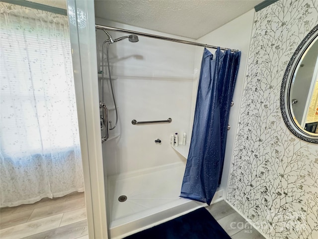 bathroom featuring hardwood / wood-style floors, a textured ceiling, and a shower with shower curtain