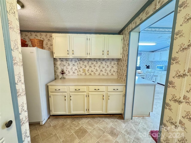 kitchen featuring a textured ceiling and white fridge