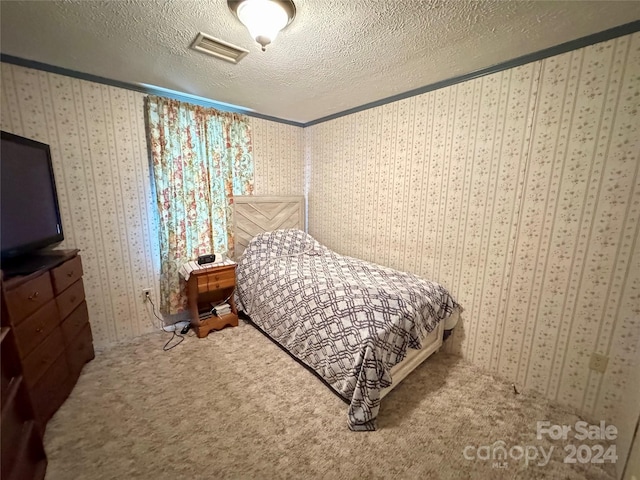 bedroom with carpet and a textured ceiling