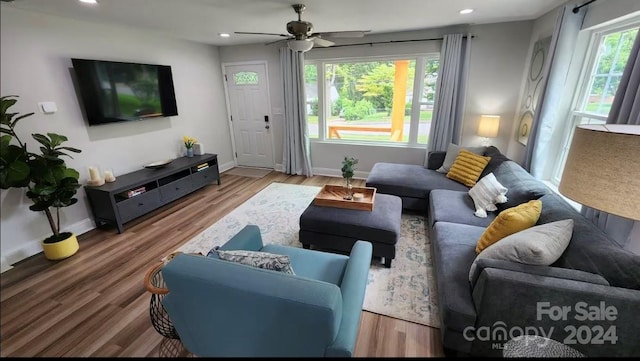 living room with a wealth of natural light, ceiling fan, and hardwood / wood-style flooring