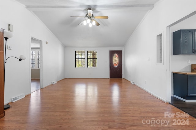 interior space with ceiling fan, wood-type flooring, and ornamental molding