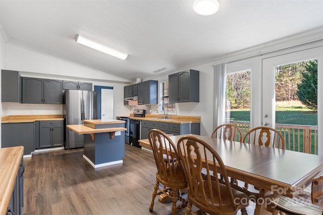 dining room featuring dark hardwood / wood-style flooring, vaulted ceiling, crown molding, and sink