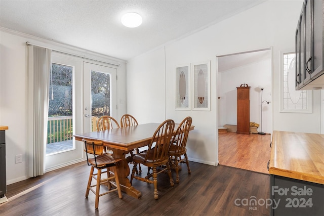 dining area featuring a textured ceiling, french doors, dark wood-type flooring, and vaulted ceiling