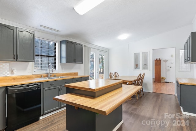 kitchen featuring dark hardwood / wood-style flooring, gray cabinetry, sink, black dishwasher, and butcher block countertops