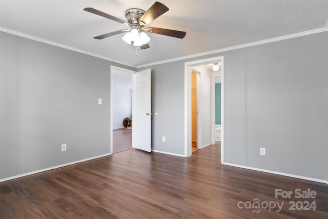 unfurnished room with a textured ceiling, ceiling fan, ornamental molding, and dark wood-type flooring