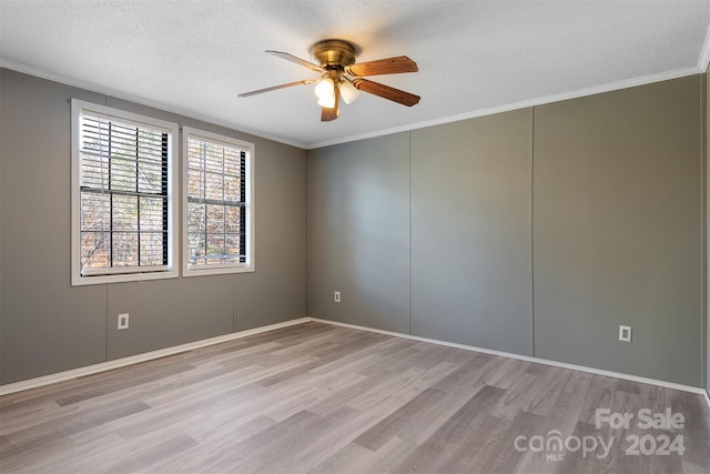 empty room with ceiling fan, light wood-type flooring, and a textured ceiling