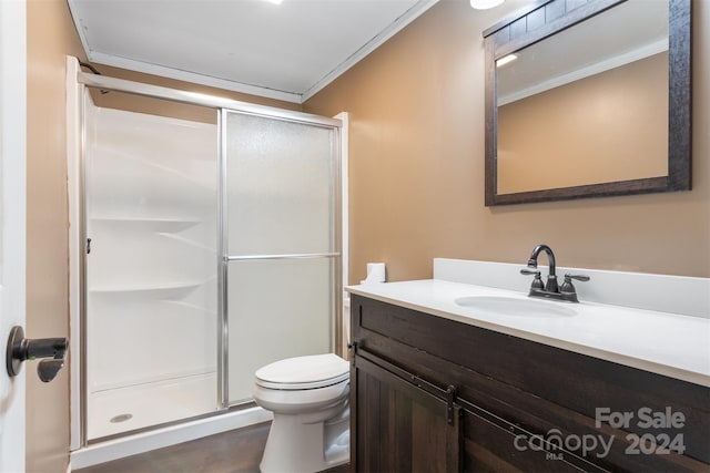 bathroom featuring vanity, a shower with door, crown molding, hardwood / wood-style flooring, and toilet