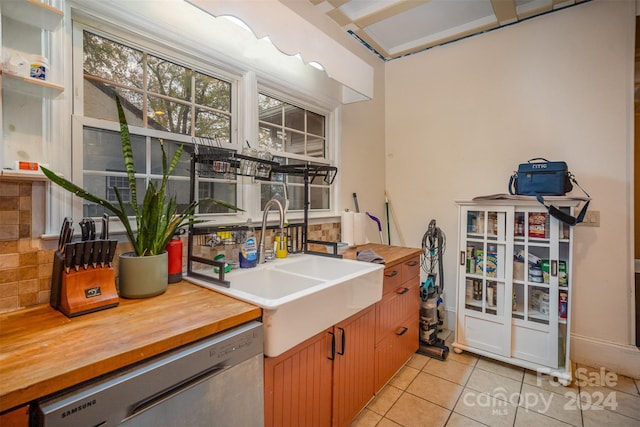 kitchen featuring dishwasher, light tile patterned flooring, sink, and tasteful backsplash