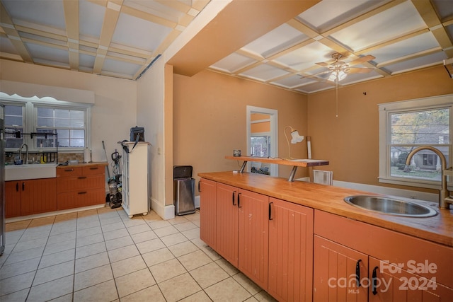 kitchen featuring ceiling fan, light tile patterned floors, and sink