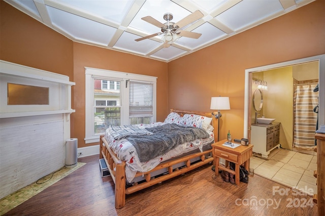 bedroom featuring beamed ceiling, wood-type flooring, ceiling fan, and coffered ceiling