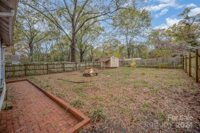 view of yard with a fire pit and a shed