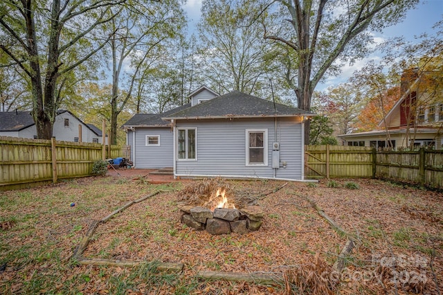 back of property with an outdoor fire pit