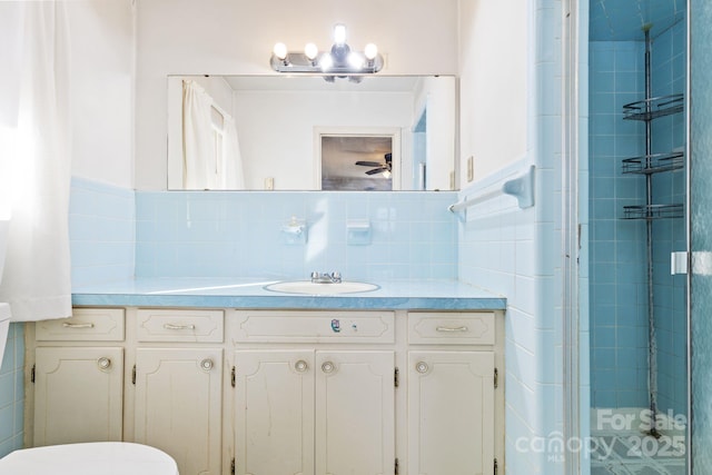 bathroom featuring vanity, an enclosed shower, and tile walls