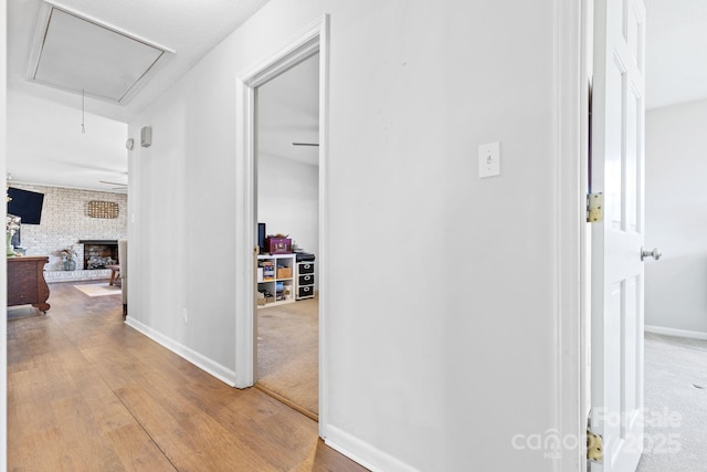 corridor with hardwood / wood-style flooring and brick wall